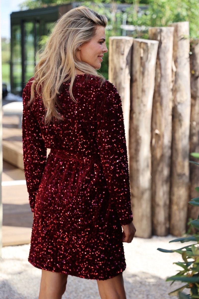 Feestelijke rode pailletten jurk met overslag halslijn en lange mouwen