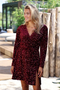 Feestelijke rode pailletten jurk met overslag halslijn en lange mouwen