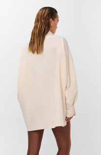 Oversized blouse in warm wit met volumineuze mouwen en opvallende zilverkleurige sierknopen.