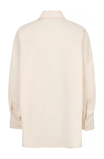 Oversized blouse in warm wit met volumineuze mouwen en opvallende zilverkleurige sierknopen.