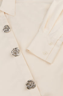 Oversized blouse in warm wit met volumineuze mouwen en opvallende zilverkleurige sierknopen.